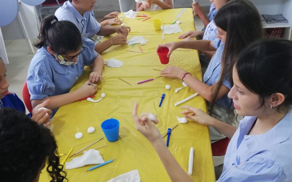Estudiantes trabajando con materiales sobre una mesa de taller